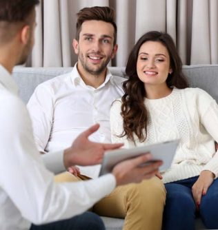 Estate agent presenting new project to happy couple